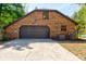 View of the oversized brick garage with a large garage door and paved driveway at 706 S Timberlane Dr, New Smyrna Beach, FL 32168