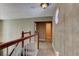 Hallway with carpeted floors, wood banister, unique lighting fixture, and a view to other rooms at 706 S Timberlane Dr, New Smyrna Beach, FL 32168