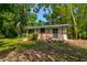Exterior of a brick and siding outbuilding surrounded by lush landscaping and trees at 706 S Timberlane Dr, New Smyrna Beach, FL 32168