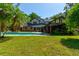 Beautiful backyard with a large pool, lush landscaping, and inviting outdoor space at 706 S Timberlane Dr, New Smyrna Beach, FL 32168