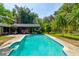 Inviting in-ground pool with a covered patio area, perfect for relaxing and entertaining at 706 S Timberlane Dr, New Smyrna Beach, FL 32168