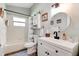Bright bathroom featuring white vanity with black fixtures, a round mirror, and a shower/bath combo with curtain at 706 Sky Tree Ct, New Smyrna Beach, FL 32168