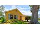 Side view of a yellow single-story home showcasing well-kept landscaping and an attached two-car garage at 706 Sky Tree Ct, New Smyrna Beach, FL 32168