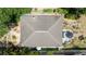 Aerial view showcases the home's roof and backyard with a hot tub, shed, and patio area at 825 E 23Rd Ave, New Smyrna Beach, FL 32169