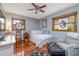 Cozy bedroom with hardwood floors, a ceiling fan, and two bright windows at 825 E 23Rd Ave, New Smyrna Beach, FL 32169