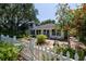 Landscaped front yard showcasing a white picket fence and mature trees at 825 E 23Rd Ave, New Smyrna Beach, FL 32169