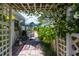 Landscaped outdoor patio area with pergola, potted plants, and outdoor seating area with an umbrella at 825 E 23Rd Ave, New Smyrna Beach, FL 32169