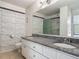 Well lit bathroom with double granite sinks, decorative mirror and tile accent wall at 95 Moonstone Ct, Port Orange, FL 32129