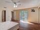 Sunlit main bedroom with wood floors, ceiling fan, closet, and sliding glass doors to a balcony at 95 Moonstone Ct, Port Orange, FL 32129