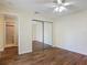 This bedroom features a ceiling fan, mirrored closet, and wood-look flooring at 95 Moonstone Ct, Port Orange, FL 32129