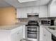 Updated kitchen with white cabinets, stainless steel appliances, granite countertops, and mosaic backsplash at 95 Moonstone Ct, Port Orange, FL 32129