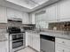 Bright kitchen features white cabinets, stainless appliances, granite counters, and stylish tile backsplash at 95 Moonstone Ct, Port Orange, FL 32129