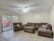 Inviting living room with wood-look tile, comfortable seating, and a sliding door to a private outdoor area at 95 Moonstone Ct, Port Orange, FL 32129