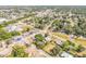 A wide aerial view showcases homes amidst trees, a nearby pond, and glimpses of the cityscape at 995 16Th St, Edgewater, FL 32132