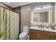 Modern bathroom features sleek wood vanity, decorative mirror, and stylish shower curtain at 995 16Th St, Edgewater, FL 32132