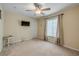 Neutral bedroom with beige walls, carpet floors, ceiling fan, and window with curtains at 995 16Th St, Edgewater, FL 32132