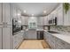 Well-lit kitchen with gray cabinets, stainless steel appliances, quartz countertops, and stylish backsplash at 995 16Th St, Edgewater, FL 32132