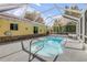 Screened-in pool with sunlit water and accessible entry steps, surrounded by lush greenery at 995 16Th St, Edgewater, FL 32132