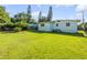 Spacious backyard with a light blue home and healthy green grass at 114 Hickory St, New Smyrna Beach, FL 32168