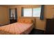 This bedroom features blue carpet with a double bed, dresser, and windows that provide plenty of natural light at 114 Hickory St, New Smyrna Beach, FL 32168