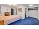 Comfortable bedroom featuring blue carpet with a double bed, dresser, and closet space at 114 Hickory St, New Smyrna Beach, FL 32168