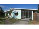 Quaint exterior showcasing a screened porch and manicured lawn, creating an inviting outdoor living space at 114 Hickory St, New Smyrna Beach, FL 32168