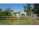 Cozy home with a quaint, wooden fence and mature trees, offering curb appeal and privacy at 114 Hickory St, New Smyrna Beach, FL 32168
