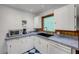 Cozy kitchen with white cabinets, ample counter space, and natural light at 114 Hickory St, New Smyrna Beach, FL 32168