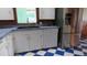 Bright kitchen features white cabinets, stainless steel appliances, and checkered flooring at 114 Hickory St, New Smyrna Beach, FL 32168