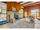 Cozy living room featuring wood paneling, fireplace and hearth, and ample seating and decor at 114 Hickory St, New Smyrna Beach, FL 32168