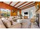 Comfortable living room features wood-paneled walls, beamed ceilings, and a cozy fireplace at 114 Hickory St, New Smyrna Beach, FL 32168