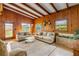 Bright living room featuring wood-paneled walls, beamed ceilings and view of outdoors at 114 Hickory St, New Smyrna Beach, FL 32168