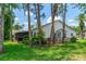Backyard view of the home highlighting a screened in patio with the lush greenery of the landscaping at 115 Bob White Ct, Daytona Beach, FL 32119