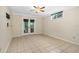 Spacious bedroom features tile floors, ceiling fan, and double doors to the backyard at 115 Bob White Ct, Daytona Beach, FL 32119