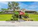 The Pelican Bay Country Club featuring a covered entrance, mature trees, and lovely landscaping at 115 Bob White Ct, Daytona Beach, FL 32119