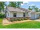 The front of a home displays a well-kept lawn, gray window frames and a gravel garden at 115 Bob White Ct, Daytona Beach, FL 32119
