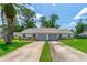 Inviting home with a well-manicured front lawn, long driveway, attached garages, and a neatly kept landscape at 115 Bob White Ct, Daytona Beach, FL 32119