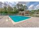 Community pool with a pristine clear blue water, a lounge area, and surrounding white picket fence at 115 Bob White Ct, Daytona Beach, FL 32119