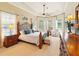 Luxury main bedroom suite with tray ceiling, many windows, sitting area and wood furniture at 128 Godfrey Rd, Edgewater, FL 32141