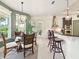 Sunlit breakfast nook boasts a modern light fixture and views of the lush outdoor space at 128 Godfrey Rd, Edgewater, FL 32141