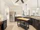 Gourmet kitchen has stainless refrigerator, island with butcher block, granite countertops, & tile flooring at 128 Godfrey Rd, Edgewater, FL 32141