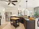 An open kitchen boasts stainless steel appliances, dark cabinetry, and an island at 128 Godfrey Rd, Edgewater, FL 32141