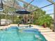 Beautiful pool with a spa feature, surrounded by tropical plants and a screened enclosure at 128 Godfrey Rd, Edgewater, FL 32141