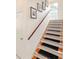 Well-lit staircase with wood treads, carpet runners, white risers, and a wooden handrail at 128 Godfrey Rd, Edgewater, FL 32141
