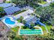 Aerial view of a community pool with lounge chairs, shuffleboard court, parking area and trees at 1307 Wayne Ave, New Smyrna Beach, FL 32168