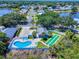 Aerial view of a community pool, shuffleboard, and clubhouse with beautiful landscaping and mature trees at 1307 Wayne Ave, New Smyrna Beach, FL 32168