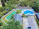 Aerial view of a pool and shuffleboard court surrounded by trees and lush landscaping at 1307 Wayne Ave, New Smyrna Beach, FL 32168