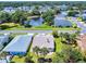 Aerial view of a well-maintained home with lush landscaping, next to a scenic pond and neighboring houses at 1307 Wayne Ave, New Smyrna Beach, FL 32168