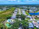 Aerial view of the neighborhood with houses, a community pool, shuffleboard court, pond, and trees at 1307 Wayne Ave, New Smyrna Beach, FL 32168