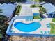 Aerial view of a community pool with a fenced area and lounge chairs perfect for relaxation at 1307 Wayne Ave, New Smyrna Beach, FL 32168